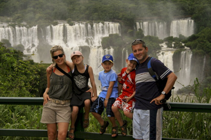Eine Familie posiert für ein Foto bei den Iguazú-Wasserfällen
